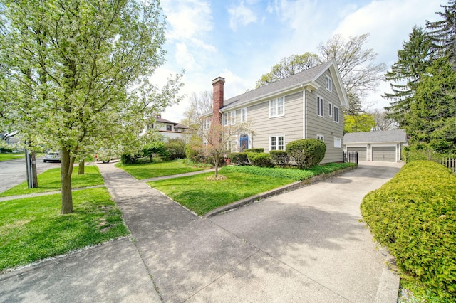 206 S Webster St, Jackson, MI 49203 - view of front of home with a garage, an outbuilding, a chimney, and a front lawn