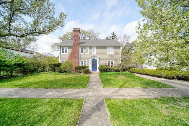 206 S Webster St, Jackson, MI 49203 - colonial home with a chimney, fence, and a front yard