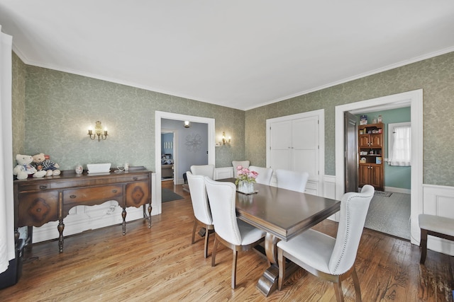 206 S Webster St, Jackson, MI 49203 - dining area featuring crown molding, light wood finished floors, a wainscoted wall, and wallpapered walls