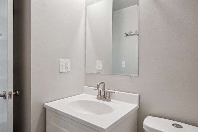 half bathroom featuring toilet and vanity