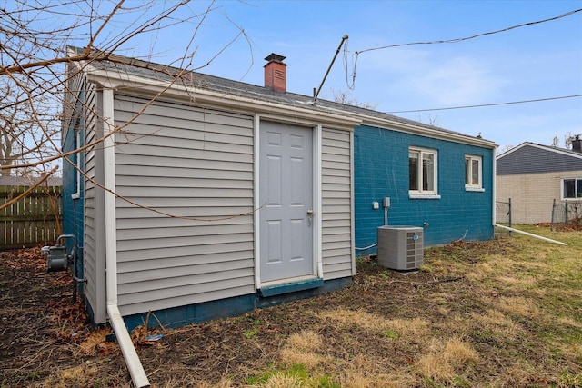 view of outbuilding featuring central air condition unit, an outbuilding, and fence