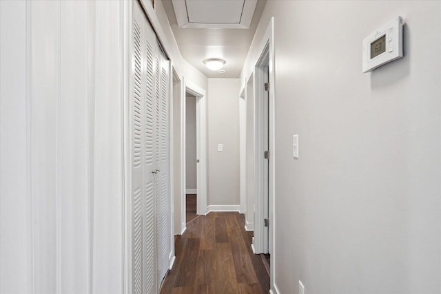 corridor featuring baseboards and dark wood finished floors