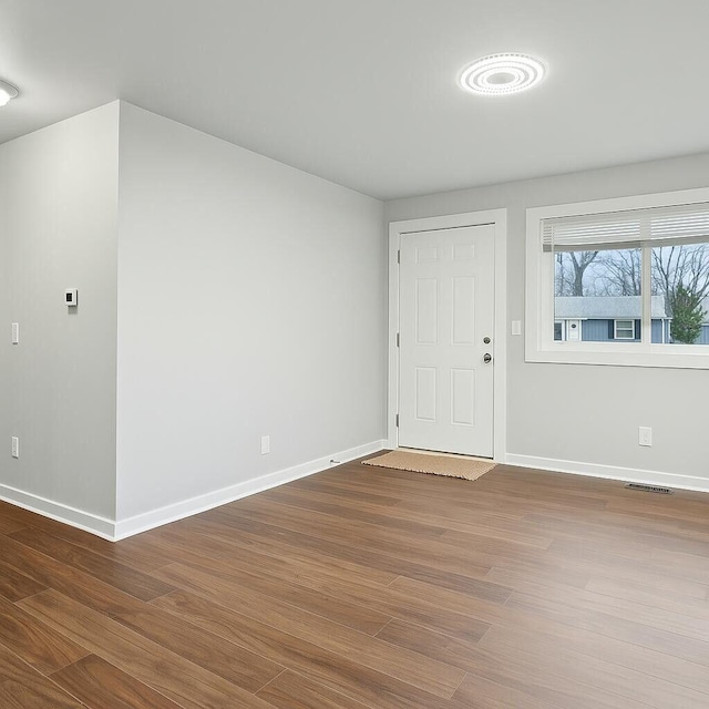 entryway featuring baseboards, wood finished floors, and visible vents