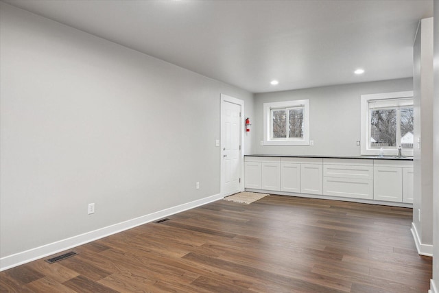 interior space with recessed lighting, baseboards, visible vents, and dark wood finished floors