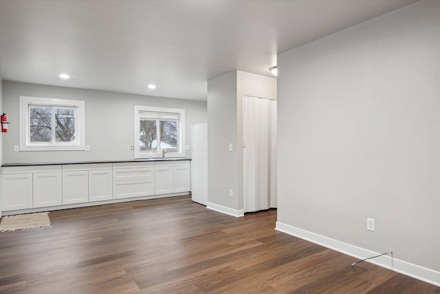 empty room with baseboards, recessed lighting, dark wood-style floors, and a wealth of natural light