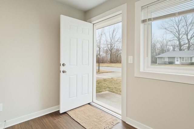 doorway to outside with baseboards and wood finished floors