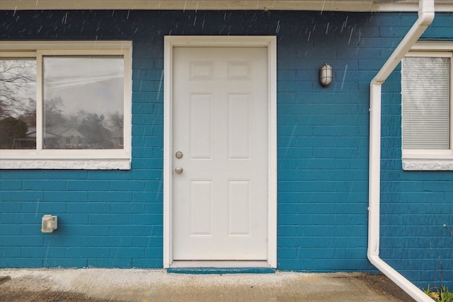 doorway to property with concrete block siding