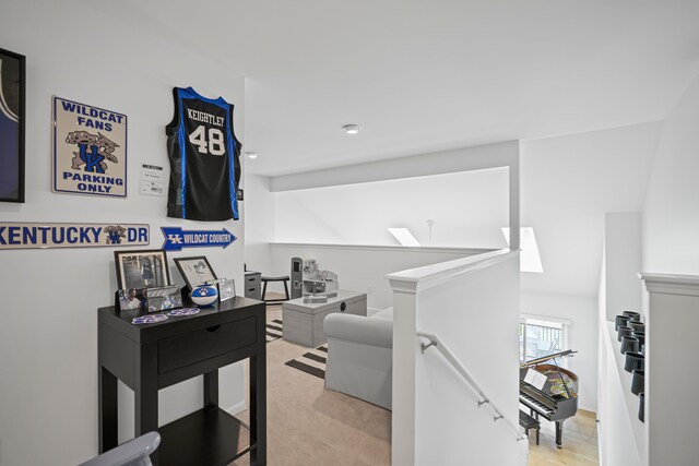 hallway featuring an upstairs landing and light carpet