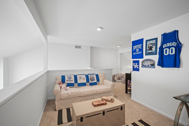 living area with baseboards, visible vents, and light carpet