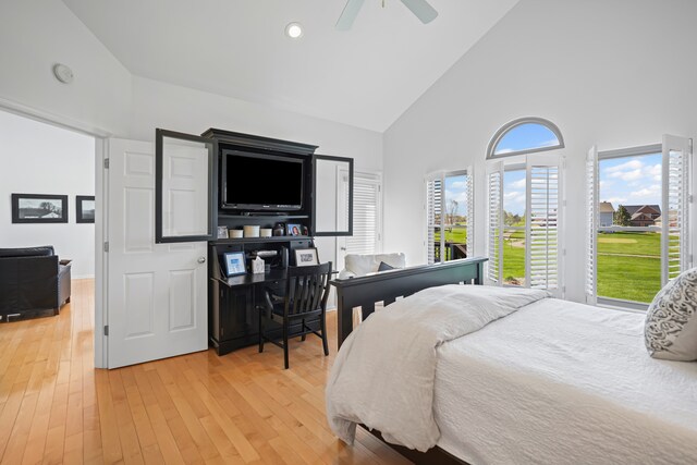 bedroom with light wood-style floors, ceiling fan, high vaulted ceiling, and access to exterior