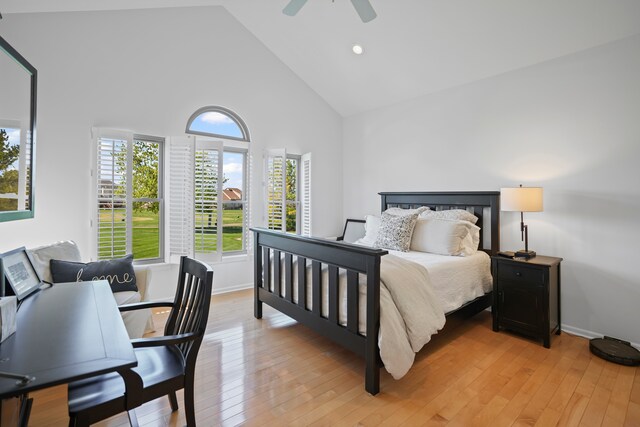 bedroom featuring high vaulted ceiling, multiple windows, ceiling fan, and light wood finished floors