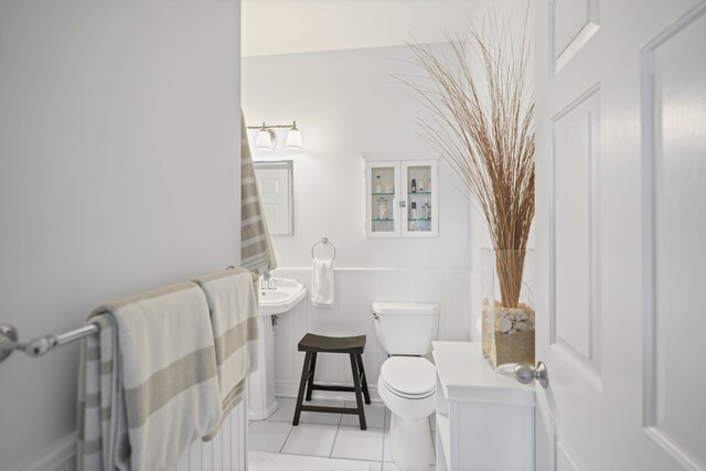 half bath featuring tile patterned flooring and toilet