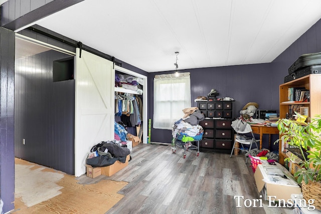 interior space featuring a barn door, wood finished floors, and wood walls
