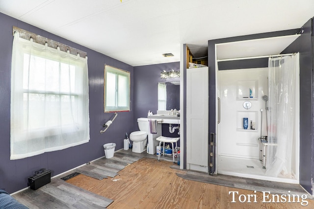 full bathroom with curtained shower, toilet, wood finished floors, and visible vents