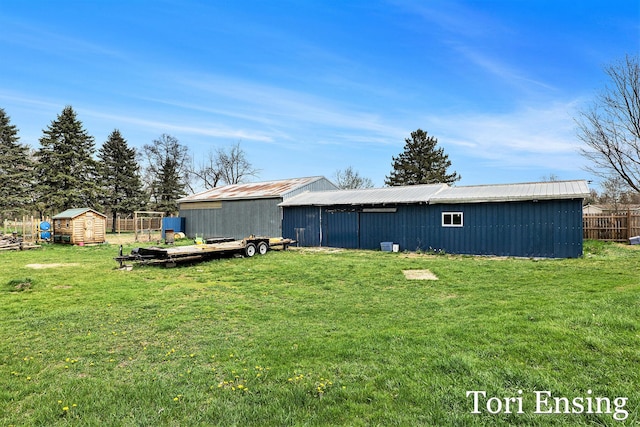 rear view of house with a lawn and an outbuilding