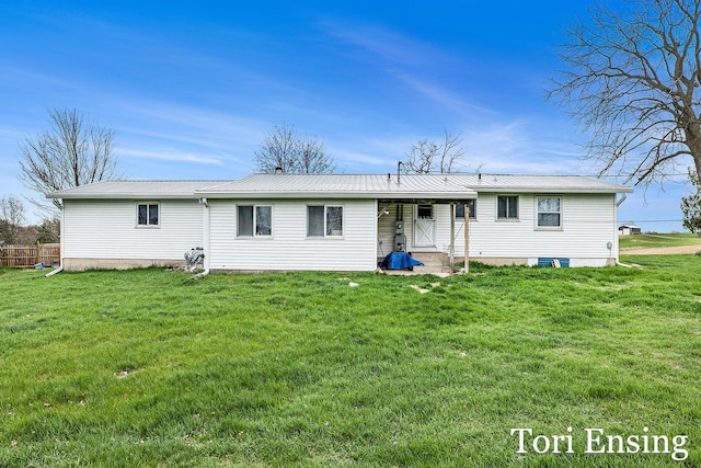 back of house with a lawn and metal roof