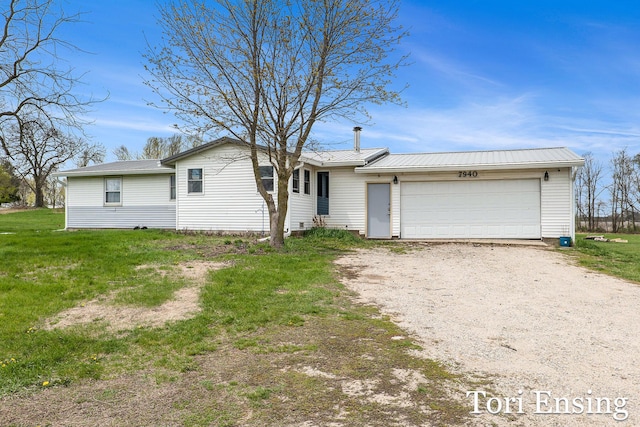 ranch-style home with driveway, metal roof, and a garage