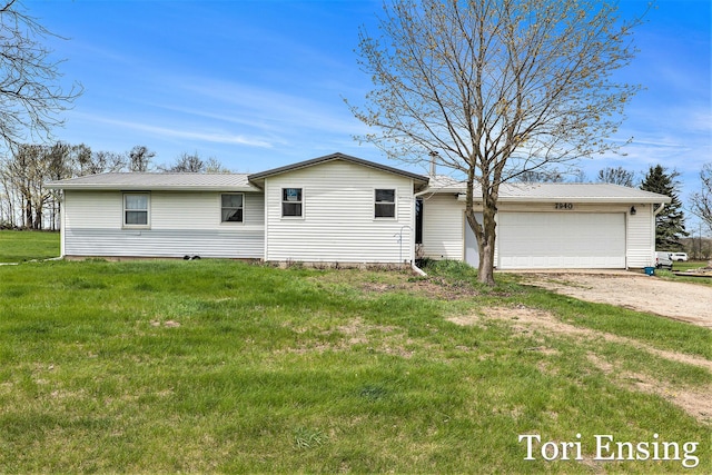 view of front of property with an attached garage, driveway, metal roof, and a front yard