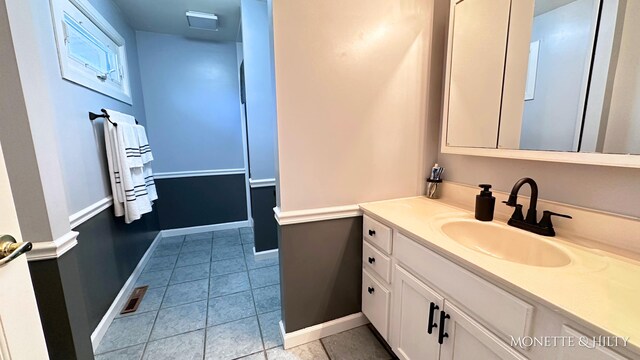 bathroom featuring baseboards, tile patterned floors, and vanity