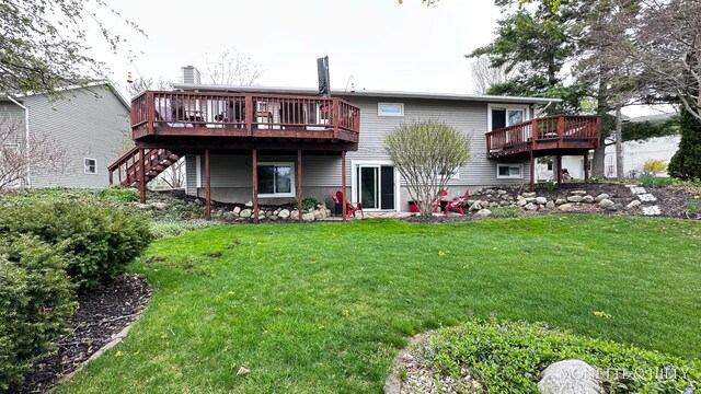 back of property featuring a lawn, stairway, and a deck