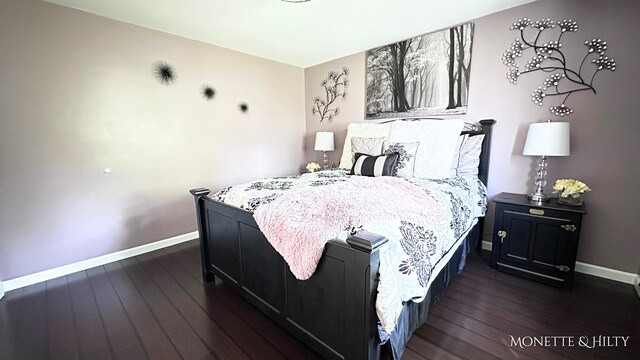 bedroom featuring baseboards and dark wood-style flooring