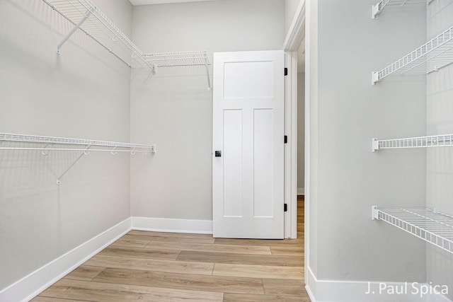 walk in closet with light wood-type flooring