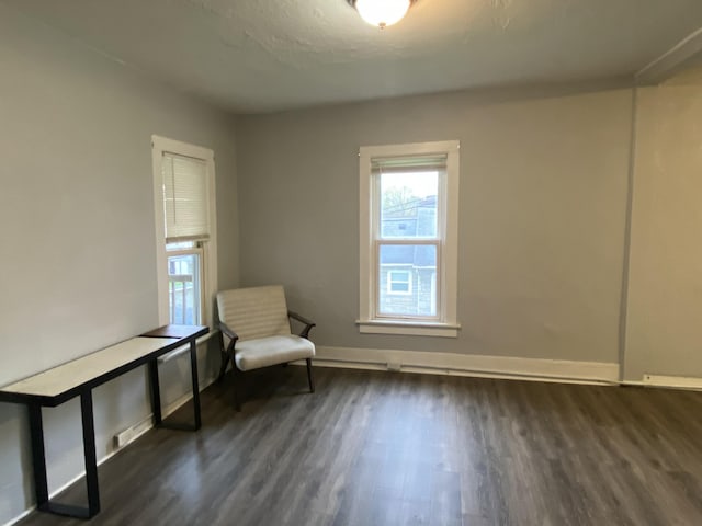 unfurnished room with baseboards, dark wood finished floors, and a healthy amount of sunlight