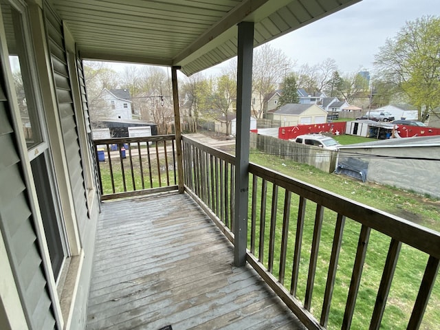 deck featuring a lawn, fence, a residential view, and an outdoor structure