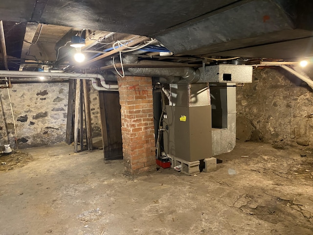 unfinished basement featuring heating unit