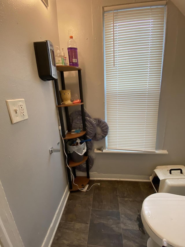 bathroom with baseboards and toilet