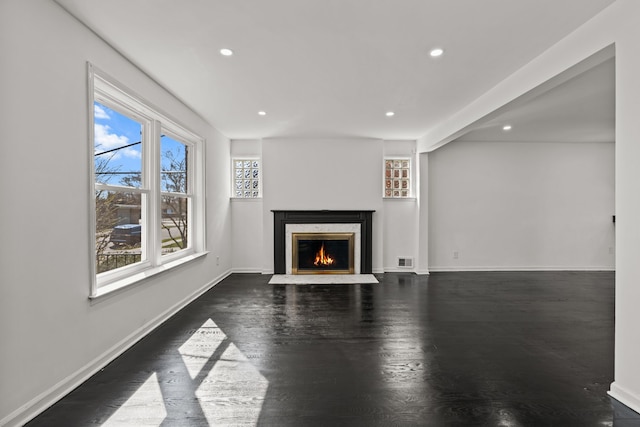unfurnished living room featuring visible vents, wood finished floors, baseboards, recessed lighting, and a premium fireplace