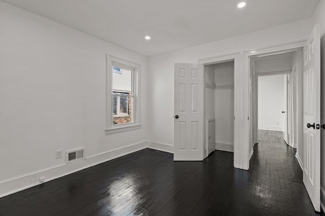unfurnished bedroom featuring dark wood-style flooring, baseboards, visible vents, and recessed lighting