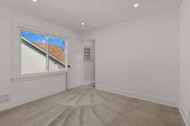unfurnished room with baseboards, recessed lighting, and light carpet