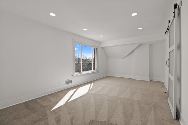 bonus room with visible vents, light carpet, baseboards, recessed lighting, and a barn door