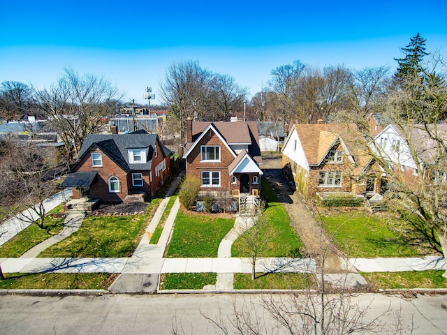 english style home featuring a residential view, driveway, and a front lawn