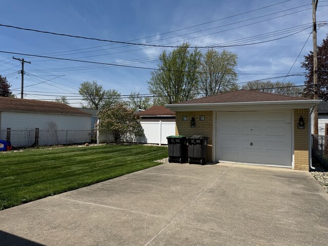 detached garage with fence and concrete driveway