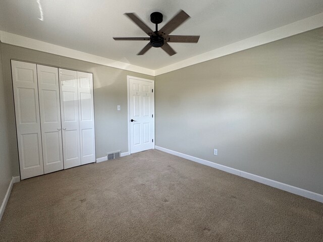unfurnished bedroom with carpet flooring, baseboards, visible vents, and a closet