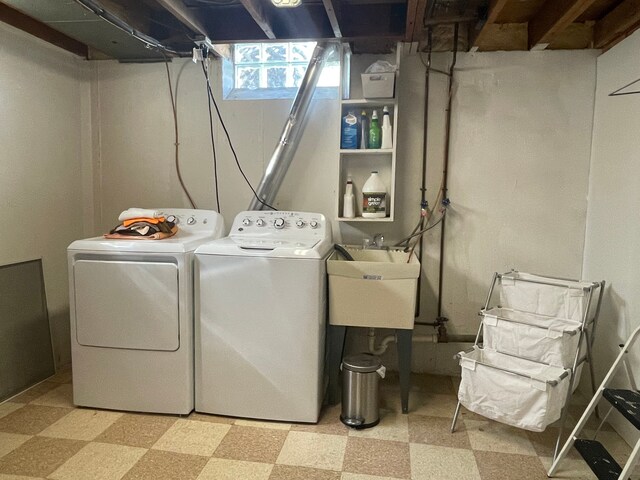 laundry area featuring laundry area, a sink, washer and clothes dryer, and light floors