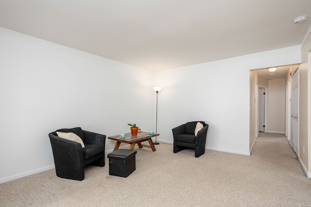 sitting room featuring baseboards, ornamental molding, and carpet