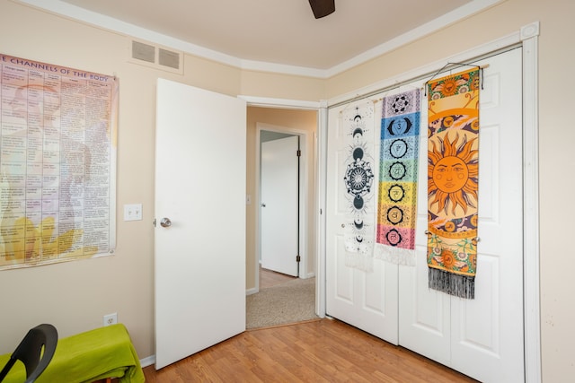 interior space with visible vents, a ceiling fan, and light wood finished floors