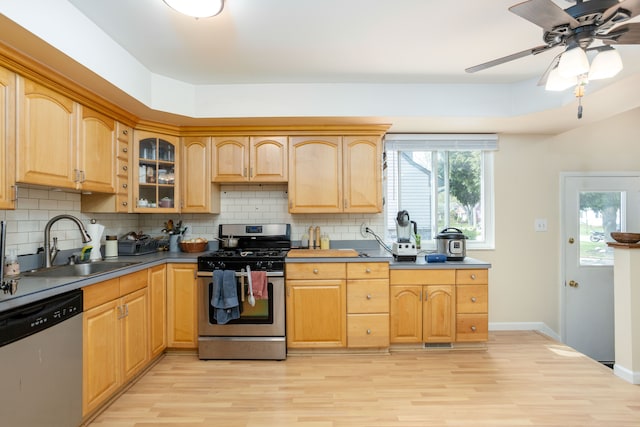 kitchen featuring a sink, light wood-style flooring, tasteful backsplash, and stainless steel appliances