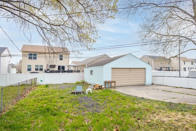 view of yard featuring a fenced backyard, an outbuilding, and a detached garage