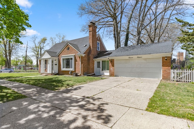 1111 N Franklin St, Dearborn, MI 48128 - view of front facade featuring a garage, a front lawn, fence, brick siding, and driveway