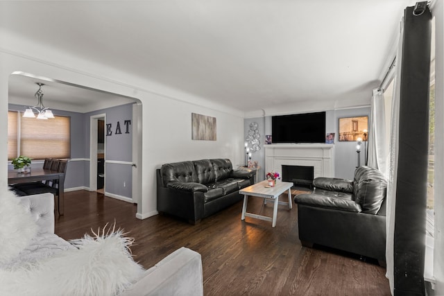 1111 N Franklin St, Dearborn, MI 48128 - living room featuring arched walkways, a fireplace, wood finished floors, baseboards, and a notable chandelier