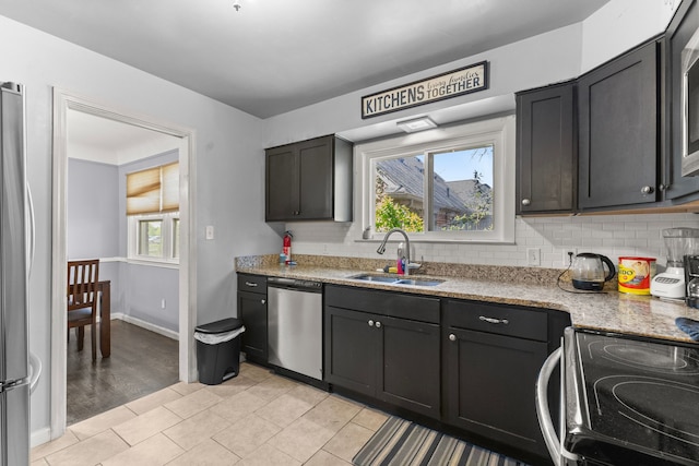 1111 N Franklin St, Dearborn, MI 48128 - kitchen featuring light stone counters, appliances with stainless steel finishes, a sink, baseboards, and tasteful backsplash