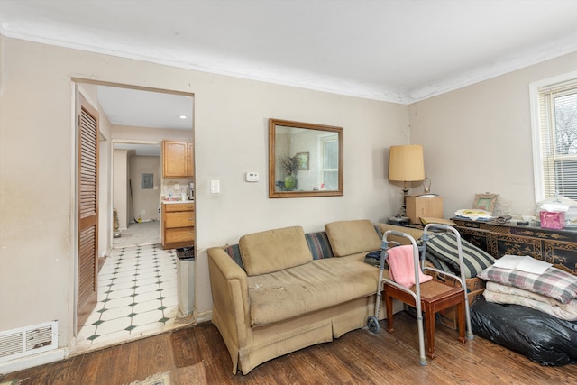 living room featuring visible vents, crown molding, and wood finished floors