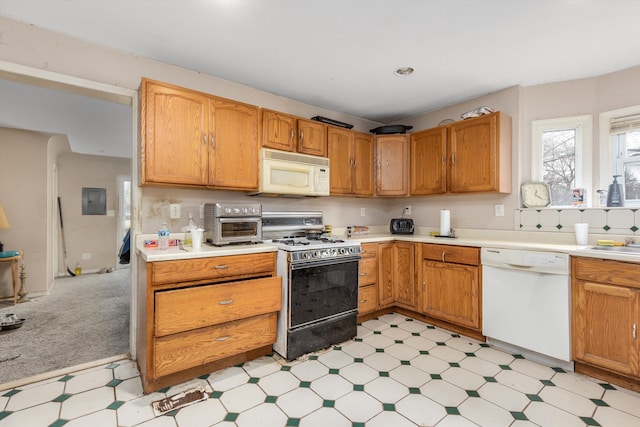kitchen featuring light countertops, light floors, a toaster, and white appliances