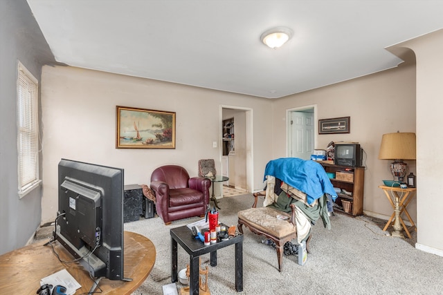 carpeted living area with baseboards