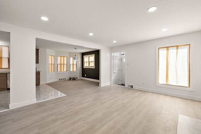 unfurnished living room featuring baseboards, recessed lighting, and visible vents