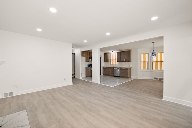 unfurnished living room with recessed lighting, baseboards, visible vents, and light wood-style flooring